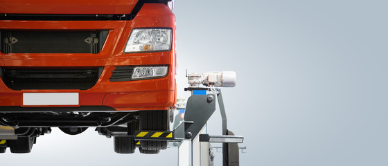 Truck on a lift in a car service. Gray background, copy space
