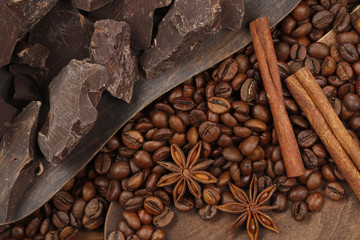 Background of chocolate pieces , cinnamon, stars anise on and Coffee beans on a wooden table. Chipped Dark Chocolate Pattern. Top view
