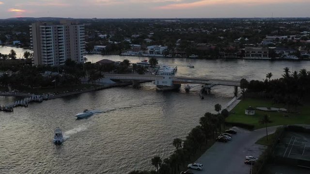 Panoramic aerial, evening dark waters, drawbridge spanning Hillsboro inlet, Pampano Beach Florida, left to right