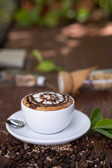topping cream pattern on a white cub of coffee on a white plate