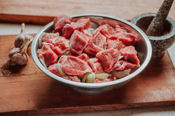 Raw pork belly pieces on a wooden cutting board