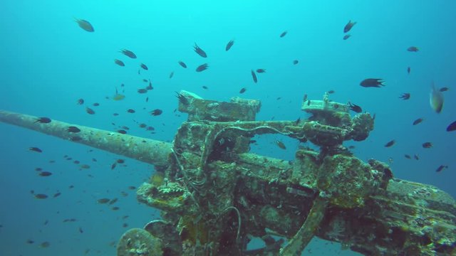 Technical wreck marine scuba diving. Old rusty wartime naval army wreckage remains on the sea bottom. Diver exploring nautical historic world war military shipwreck ruins deep under water in ocean