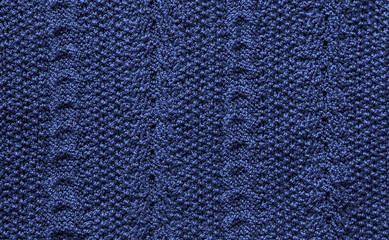 Knitted background from threads of yarn with a pattern tinted in the color of the year 2020 classic blue