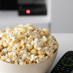 Close up of popcorn bowl and remote control for Smart tv Home cinema  and watchih Tv at home concept.