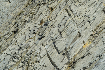 Striped natural texture of stones and rock fragments on Caucasus mountains on Black Sea coast in Olginka as original texture background. Brown, yellow, gray colored stone. Nature concept for design