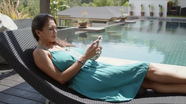 Woman using smartphone at poolside
