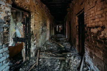 Burnt old house interior. Ruined coridor walls in black soot. Consequences of fire