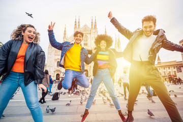 Obraz premium Group of for multiethnic people friends jumping in front of milan cathedral