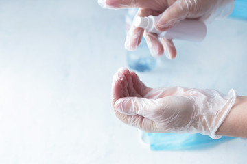 Naklejka premium hand disinfection, a woman disinfects hands with rubber gloves with a sanitizer, coronavirus