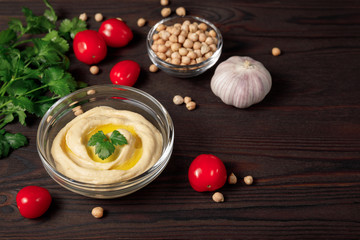 Traditional chickpea hummus bowl on wooden table background