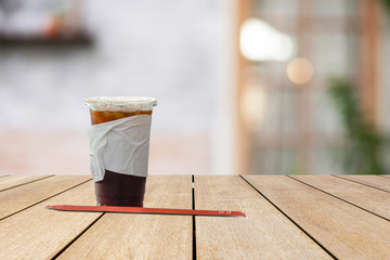 Cup of coffee put on old wood bridge shelves on blurred old loft cement wall  background.
