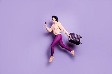 Full length profile photo of funny lady jumping high walk airport look telephone carry luggage wear...