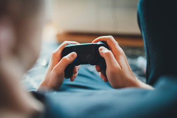 Home Leisure, Closeup of male hands holding joystick gamepad controller playing video game sitting alone in living room at home, console videogames hobby concept, Gamer man holding simulator joypad - obrazy, fototapety, plakaty