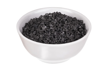 Coarse black salt in a bowl isolated on a white background. Hawaiian lava salt. Himalayan black rock salt. Thursday's salt.
