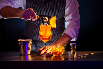 Bartender adding ice into Aperol spritz cocktail