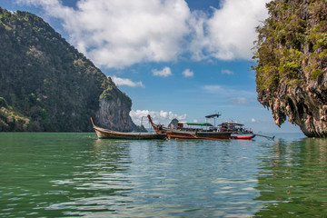 Boats in calm water near the rocky islands