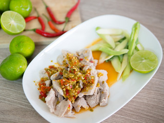 Pork with lemonade / Pork boil with chili and lime lemon sauce with herb and Vegetable on plate - Thai spicy food..