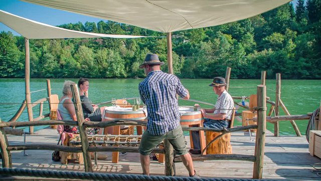 Slow motion shot of a family having a drink while navigating on a Slovenian raft on Drava river