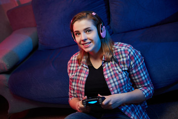 Naklejka premium Portrait of crazy playful Gamer enjoying Playing Video Games on Playstation indoors sitting on the sofa, holding Console Gamepad in hands, Xbox fans. Resting At Home, have a great Weekend