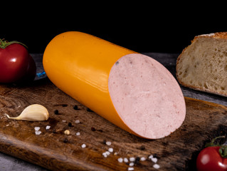 boiled sausage on a wooden board on a dark background © Андрей Мазуренко