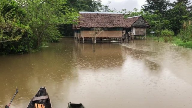 View of a lodege in the middle of the amazon jungle during a rainy day. View of cabins and canoes under a storm in the Peruvian Amazonia. Cabanas y canoas en medio de la selva amaz&oacute;nica.