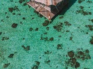 Top view aerial  happy young woman lie back at beautiful water villa at Maldives island.  Happy...