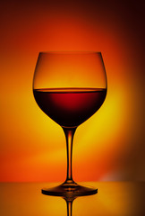 Weinglas mit rot gelber Farbmischung