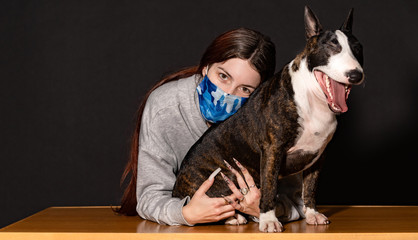young woman with her pet in confinement, bull terrier bitch