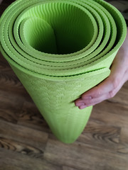 hand holds yoga mat, healthy lifestyle concept