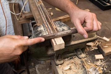 Male carpenter working on old wood in a retro vintage workshop.