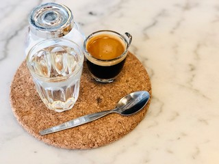 Black coffee americano on the wooden plate, house blend coffee good smell mixing with syrup in clear glasses, selective focus on foreground and blurred background, feeling freshness in the morning.