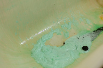 Green penn at the bottom of the old bath. Chemical agent with bleach to clean enamel. A spoiled bath is suitable for replacement. The acid color of the cleaner.