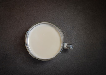 Cup of milk on the black table. Milk on black background. Glass of milk.