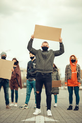 A group of people with mask and posters to protest The protest of the population against...