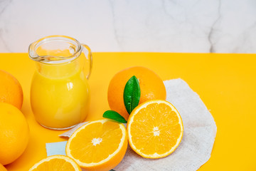Orange juice with oranges on yellow background