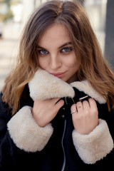 Close-up portrait of a girl wrapped in a warm jacket. young beautiful girl