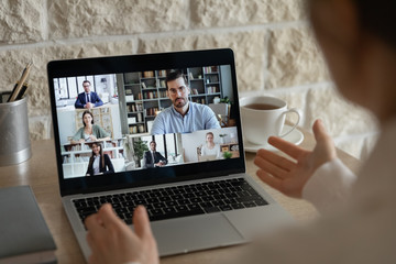 Back view of employee have webcam online conference or conversation with diverse colleagues...