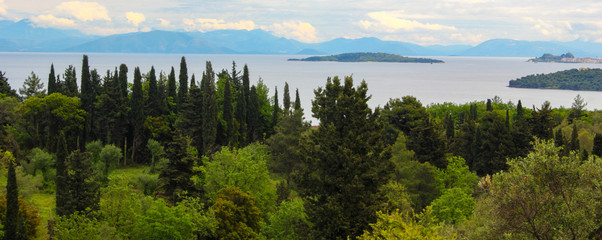 panoramic land and sea with olive and cypress tree forests islands and mountains in corfu greece