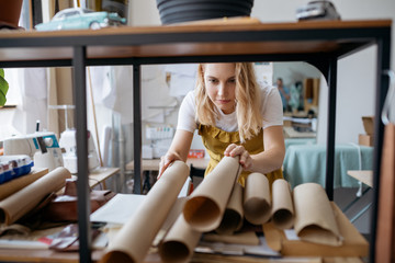 Woman working with paper patterns at her atelier. Small business and self-employed women concept.