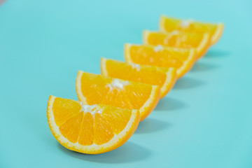 Orange slices standing in line on blue background