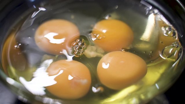 Huevo crudo cae sobre otros huevos crudos.