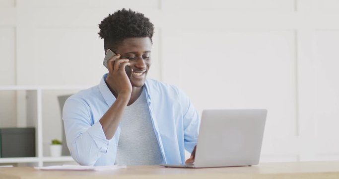 Friendly african american man talking on phone with partners