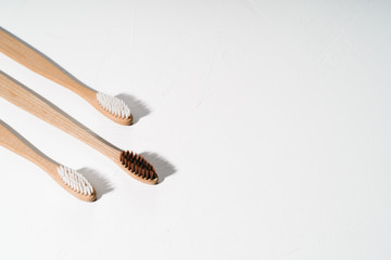 Three eco natural tothbrushes on white background. Zero waste concept. Plastic free. Copy space, top view.