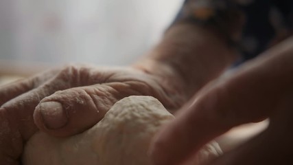 Elderly woman kneads dough, hands with wrinkles prepare homemade pasta