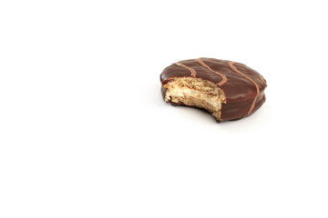A bitten chocolate pie, consisting of two small round layers of cake with cream filling and chocolate covering. 