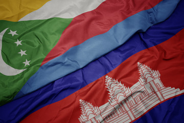 waving colorful flag of cambodia and national flag of comoros.