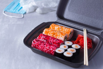 sushi delivery, home delivery in plastic and paper packaging, contactless delivery during the coronavirus epidemic