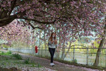 young woman with a face mask walking in the park