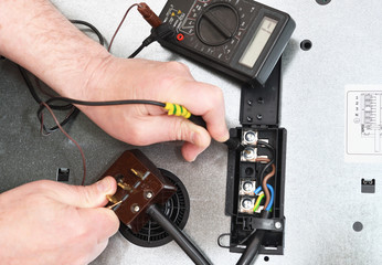 A professional electrician checks the connection quality, contact, voltage in the circuit of the...