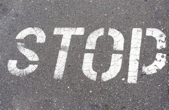 Word Stop written on an asphalt road, Stop Sign

